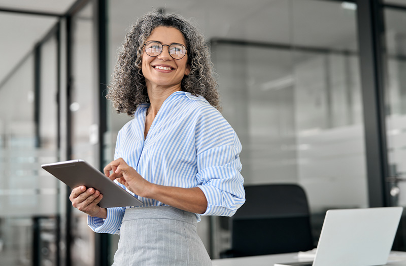 Woman smiling while holding a tablet