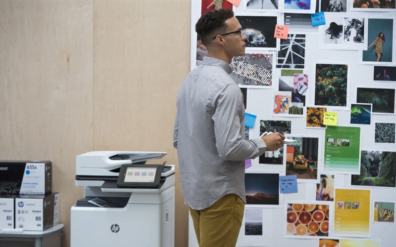 The services and supplies to keep your printer, and your business, churning. Young business man looking at all of printed papers