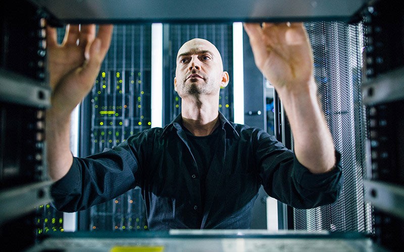 Drive your data centre forward. IT technician working on server racks found in data centre